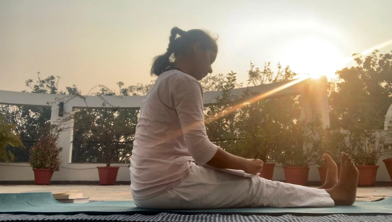 Sakshi sunbathing while journaling on her terrace